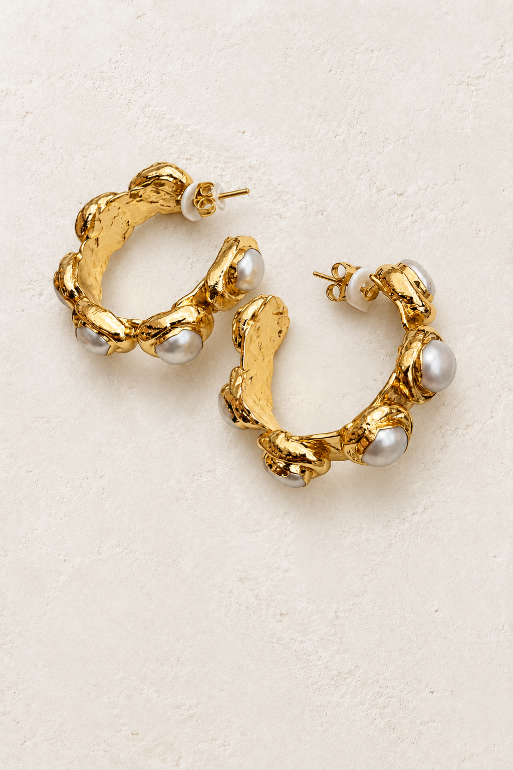 Violetta Gold Sculpted Pearl Hoops on cream plaster background