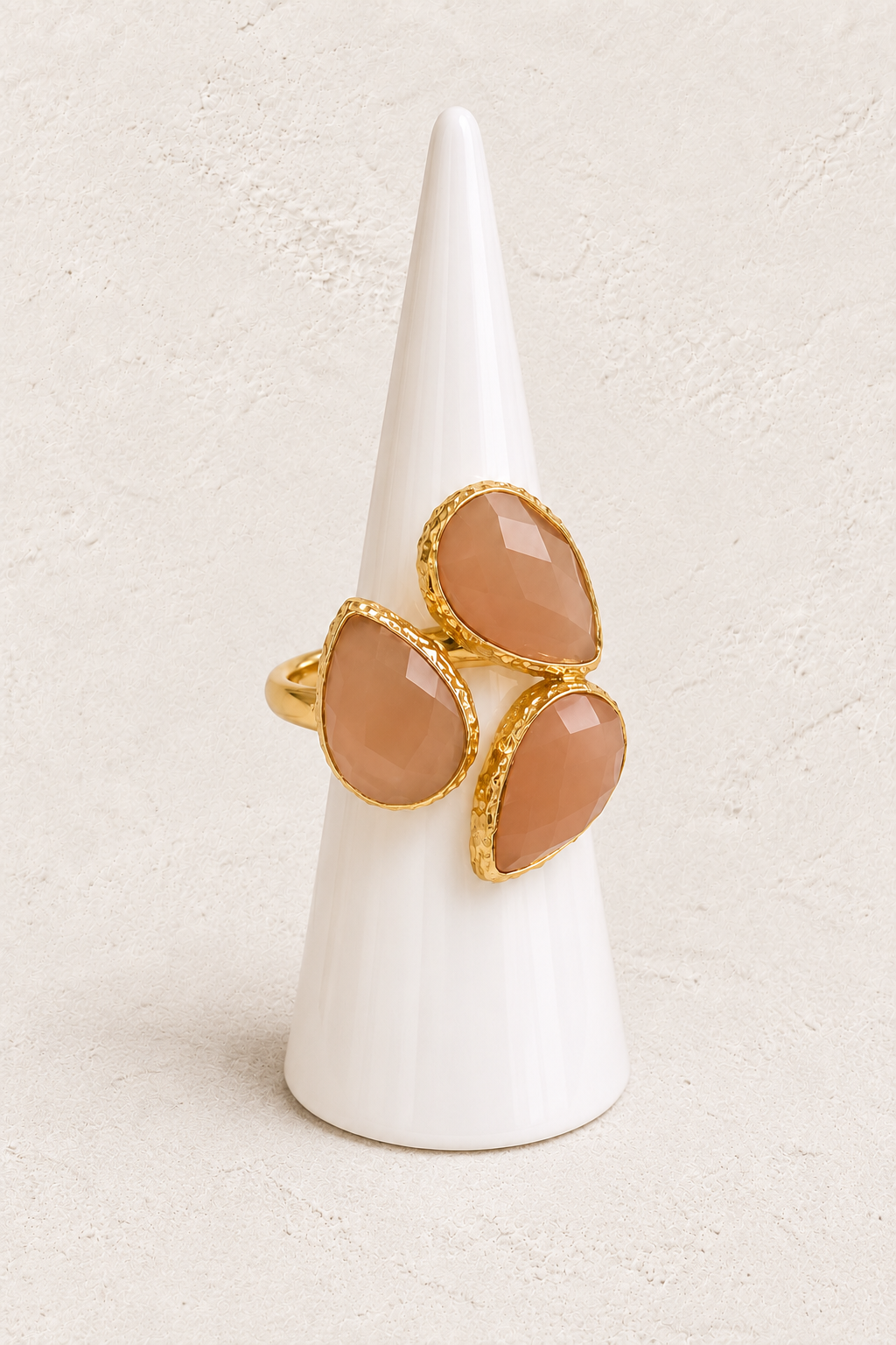 Seraphine Sunstone Ring on white cone against warm textured background