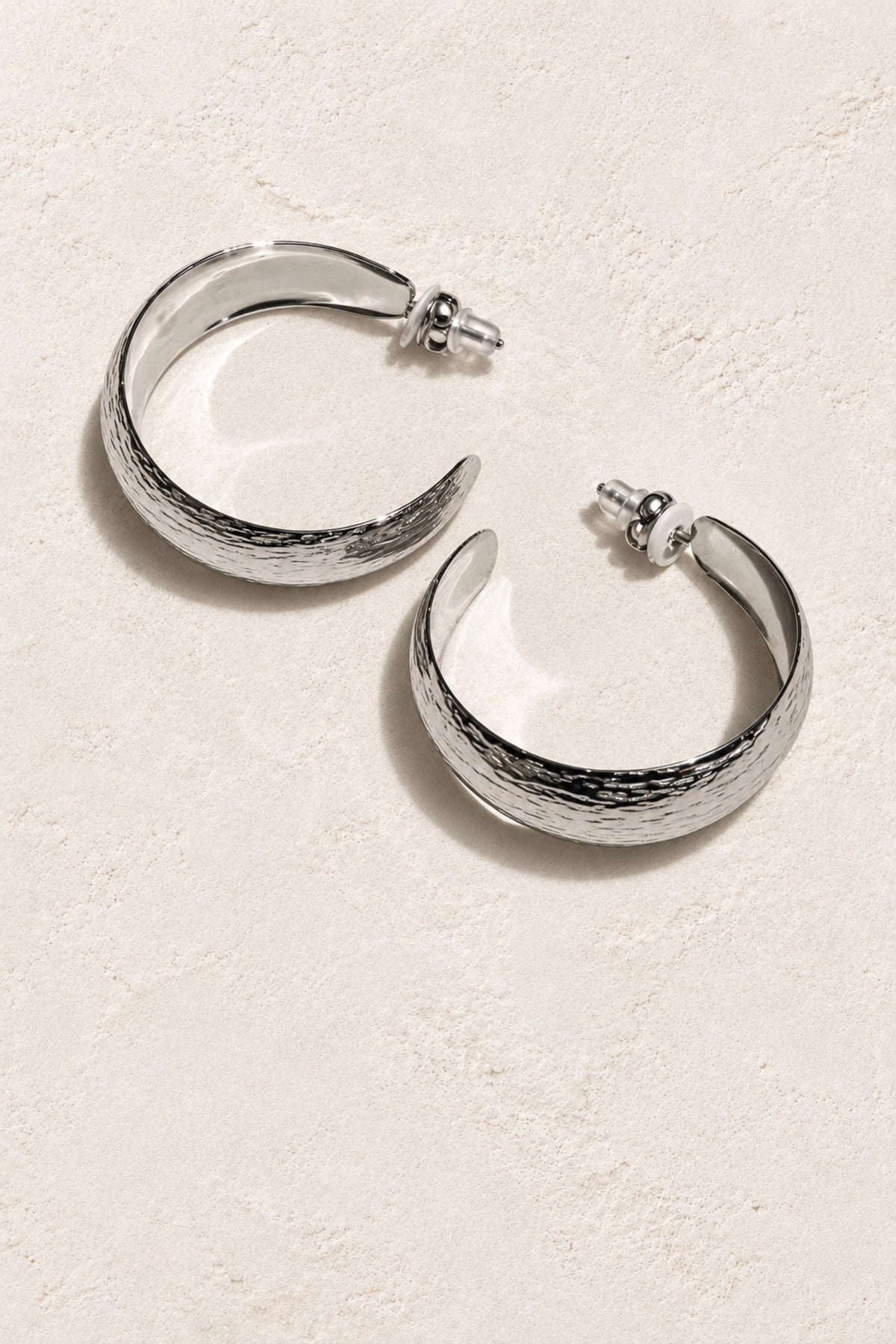 
                  
                    Zahara Silver Crescent Hoop Earrings on warm ivory plaster
                  
                